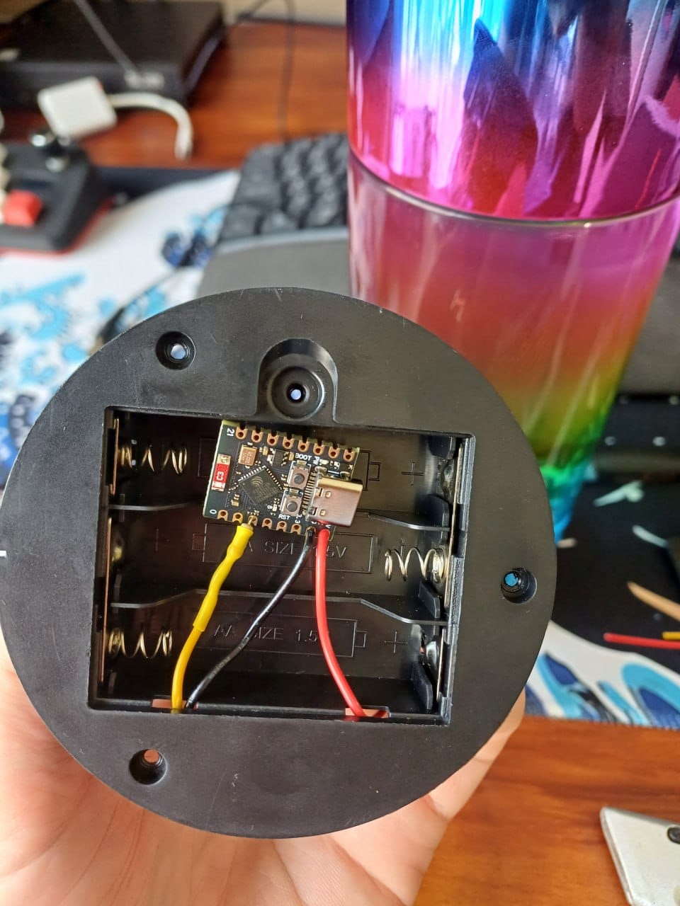 An ESP32-C3 devkit installed inside the lamp battery compartment with yellow, black and red wires