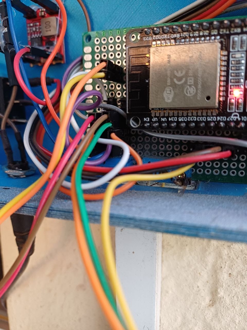 The inside of the 3D printed enclosure with the lid off, showing the ESP32 on its hand soldered protoboard and the tangle of jumper wires