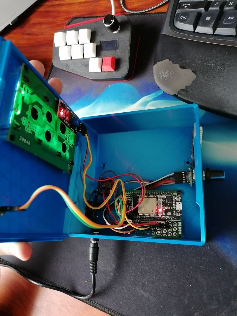 The finished 3D printed pool monitor opened up on the bench, showing the ESP32 devkit, the wiring, the rotary encoder and the audio jack connector