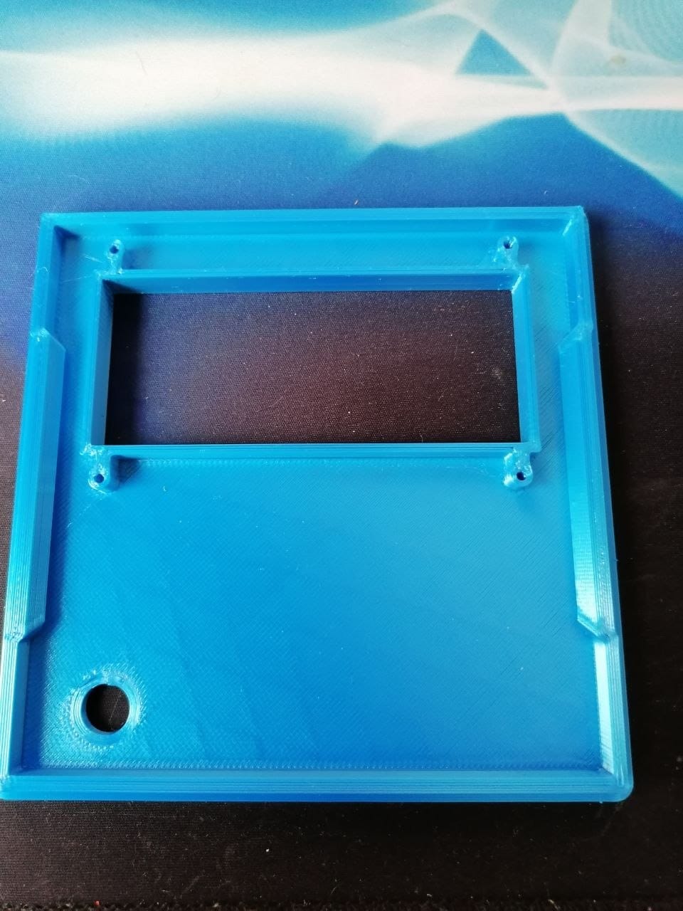 The raw 3D printed front panel with the rectangular LCD window and the round PIR hole, before any parts were fitted